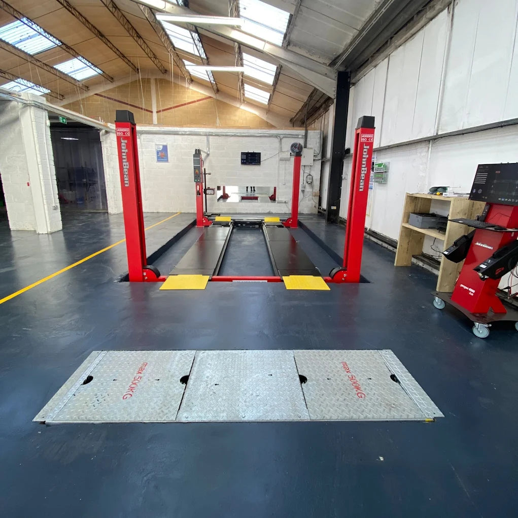 Fully equipped workshop at Quick Car Repairs in Leighton Buzzard with car ramps and repair tools